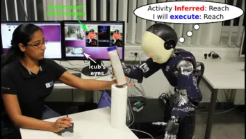 A human gives an object to a humanoid robot. In a thought bubble the robot show what it is thinking: Activity infered "reach" and executing task "reach". 