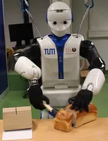 A robot from the type REEM-C cuts bread. 